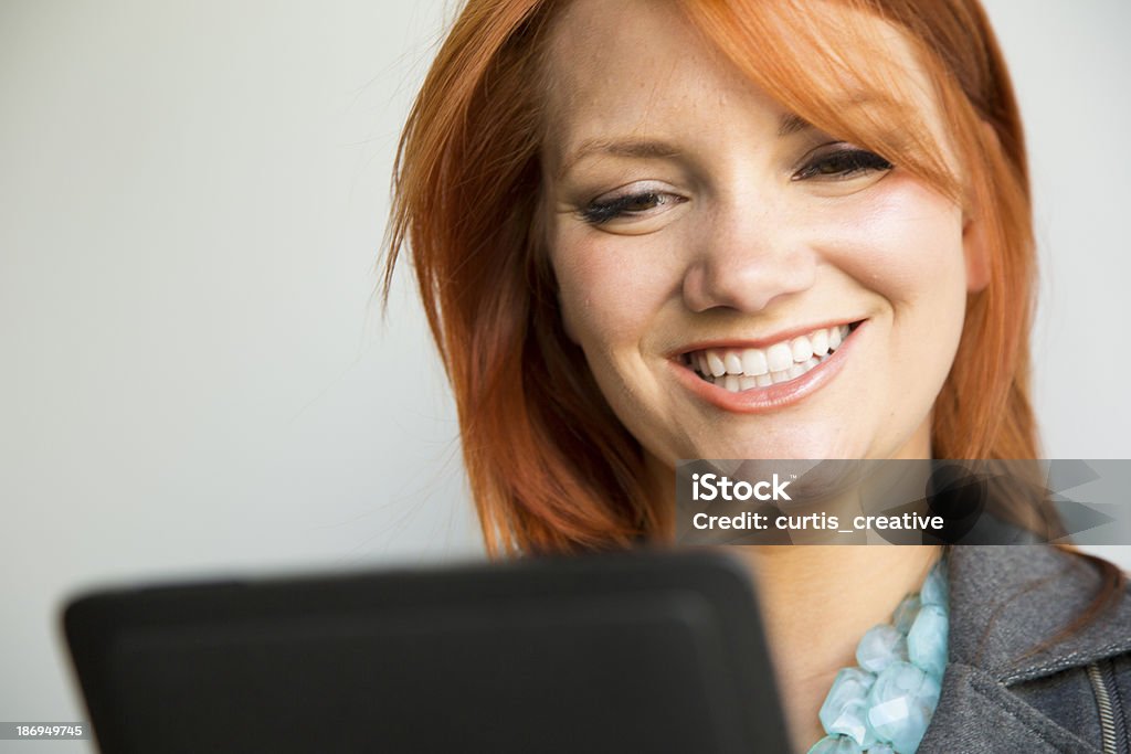 Woman Enjoying Ebook on Tablet Red hair girl enjoying ebook on tablet. 20-29 Years Stock Photo