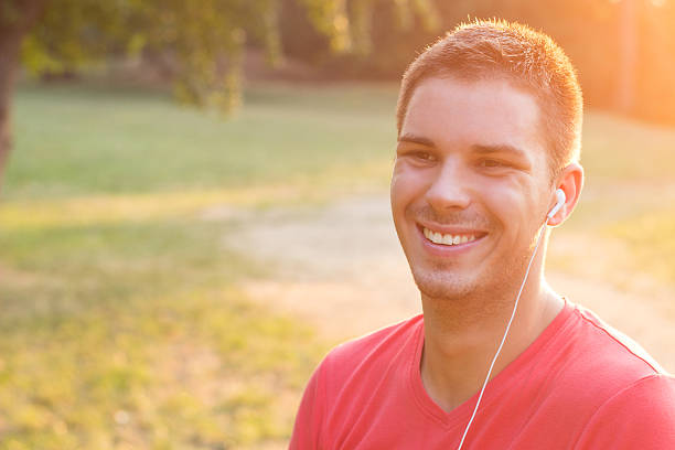 istock Smiling young man listening to music 186950008