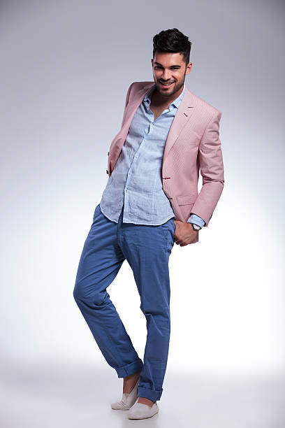 istock casual man smiles with both thumbs in pockets 186950418