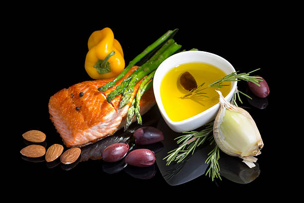 Mediterranean omega-3 diet. Mediterranean omega-3 diet. Fish steak, olives, nuts and herbs isolated on black background with reflection. mediterranean food photos stock pictures, royalty-free photos & images