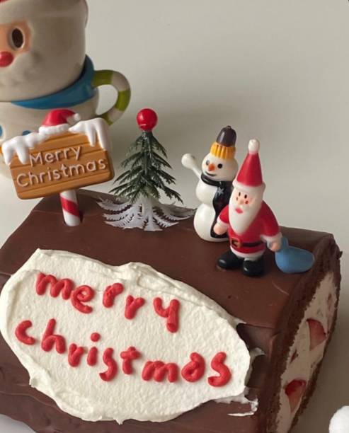 New Year's cakes, Christmas tree branches, balls, tangerines, tinsel and bow. Place for text. Festive mood of Christmas and New Year.