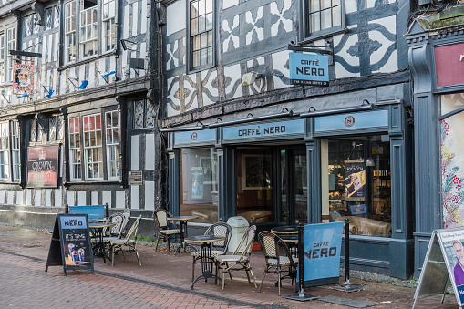 Nantwich, Cheshire, England, November 15th 2023. Half-timbered building with white and black exterior patterns, housing a Caffè Nero coffee shop.