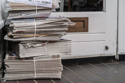 London, England, September 17th 2023. A pile of fresh newspapers with a white door in the background.