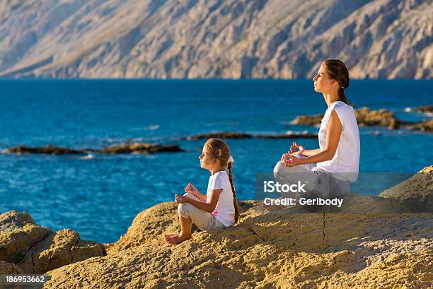 Mother And Daughter Doing Yoga Exercise On The Beach Stock Photo - Download Image Now