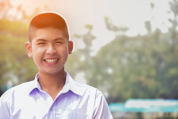 Asian school boy Asian cute schoolboy who has short hair wears white school uniform and big smile, soft focus, face and smile expression of human concept. short story stock pictures, royalty-free photos & images