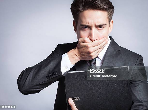 Young Business Man Covering His Mouth Stock Photo - Download Image Now - Business Person, Whispering, Adult