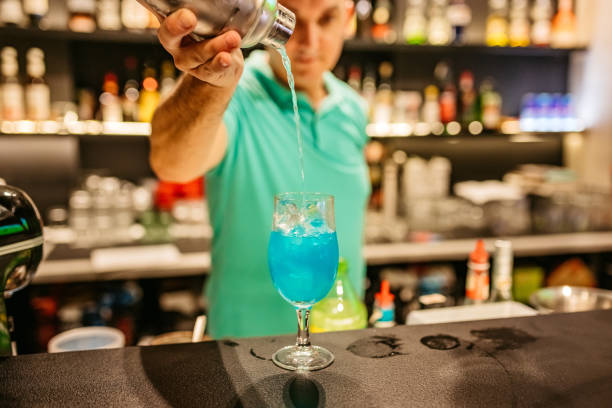 istock Mid-Adult Bartender Making A Blue Frog Cocktail On The Bar Counter 1869579951