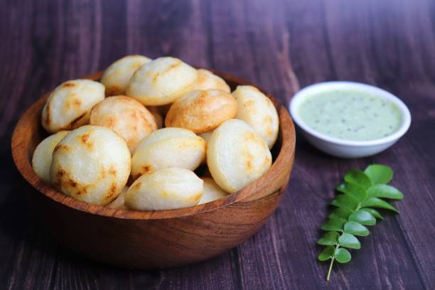istock Paniyaram are savory balls made using fermented rice and urad dal batter along with tempered onion and spices. Also known as Paddu, Ponganalu, Kuli, bugga, and appe. served with coconut chutney 1869588009