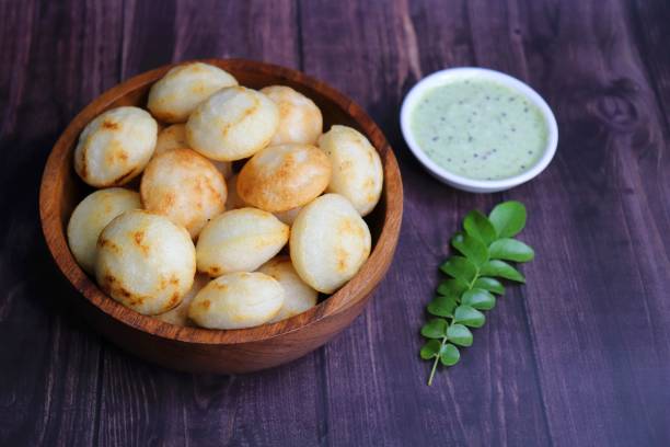 istock Paniyaram are savory balls made using fermented rice and urad dal batter along with tempered onion and spices. Also known as Paddu, Ponganalu, Kuli, bugga, and appe. served with coconut chutney 1869588012
