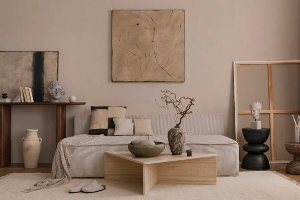 istock Creative composition of living room interior with mock up poster frame, marble coffee table, modular sofa, beige coffee table, wooden consola and personal accessories. Home decor. Template. 1869598558
