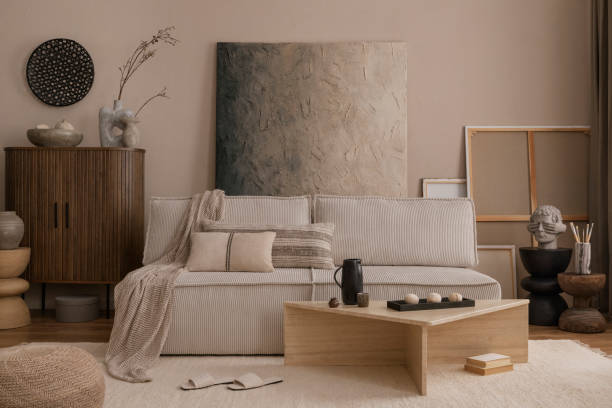 istock Warm and cozy living room interior with mock up poster frame, modular sofa, pillows, sideboard, marble coffee table, plaid, slippers, pillows and personal accessories. Home decor. Template. 1869598575