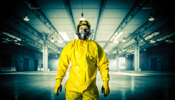Cтоковое фото Мужчина в маске и защитной одежде на складе