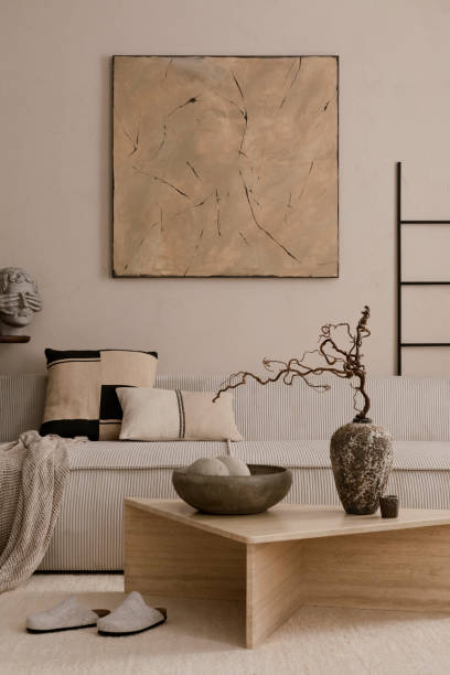 istock Creative composition of living room interior with mock up poster frame, marble coffee table, modular sofa, beige coffee table, wooden consola and personal accessories. Home decor. Template. 1869598613
