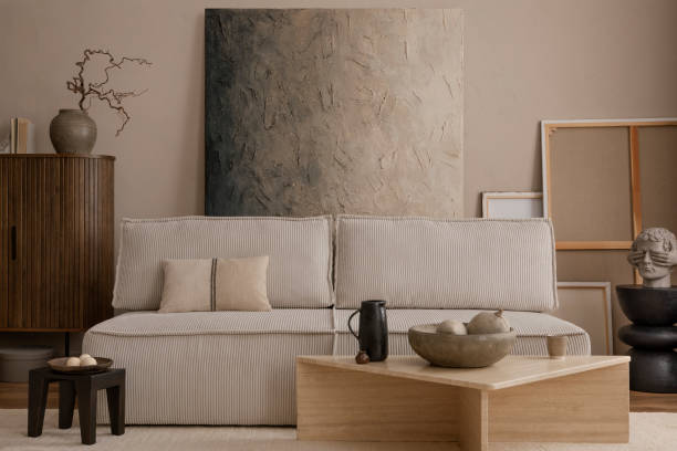 istock Creative composition of living room interior with mock up poster frame, marble coffee table, modular sofa, beige coffee table, wooden consola and personal accessories. Home decor. Template. 1869598631