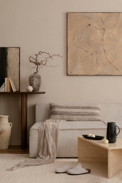 istock Creative composition of living room interior with mock up poster frame, marble coffee table, modular sofa, beige coffee table, wooden consola and personal accessories. Home decor. Template. 1869598646
