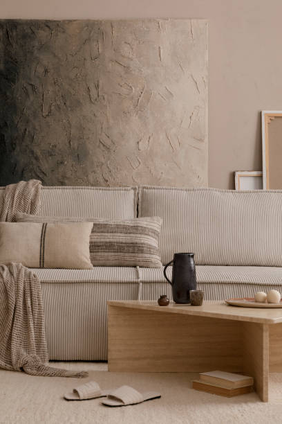 istock Creative composition of living room interior with mock up poster frame, marble coffee table, modular sofa, beige coffee table, wooden consola and personal accessories. Home decor. Template. 1869598665