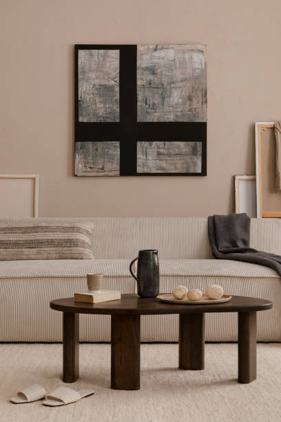 istock Creative composition of living room interior with mock up poster frame, modular sofa, wooden coffee table, beige pillow, plaid, carpet, marble bowl and personal accessories. Home decor. Template. 1869598679