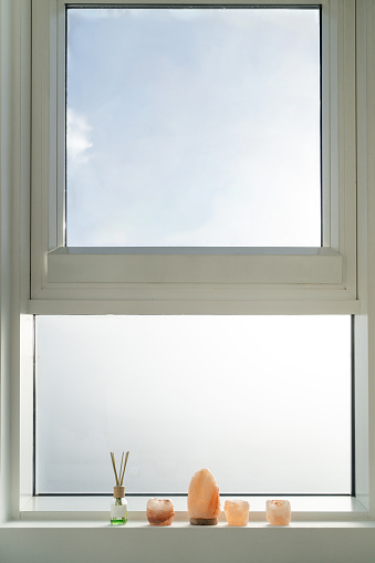 Crystals and air freshener diffuser sticks on window sill, no people