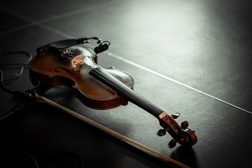 Wooden violin on the floor. Musical concept.