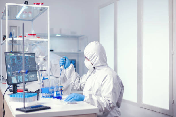 istock Doctor taking carefully sample from test tube using automatic pipette 1869659221