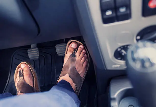 Male feet on the pedals of a car