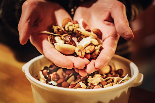 Women snacking on a handful of very nutty trail mix.