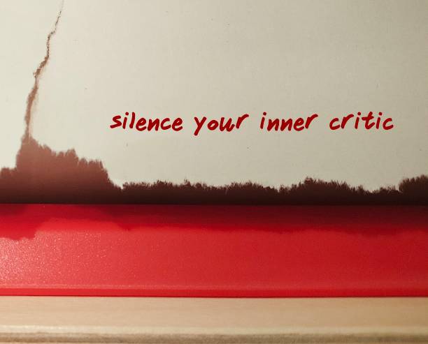 istock Torn kitchen paper with text written Silence Your Inner Critic - self talk to tame negative inner voice and overcome negativity which lower confidence and self-worth 1869681402