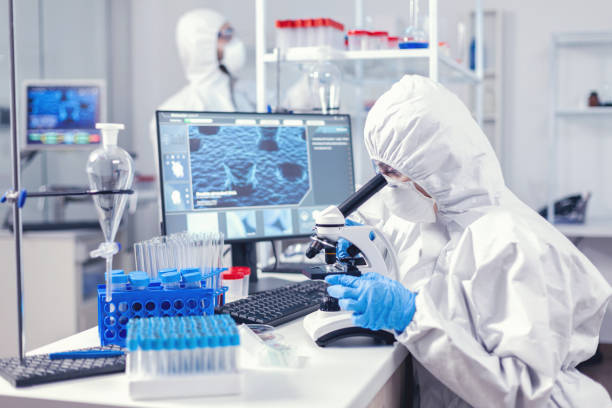 istock Team of medical personal wearing ppe suit doing coronavirus analysis 1869681967