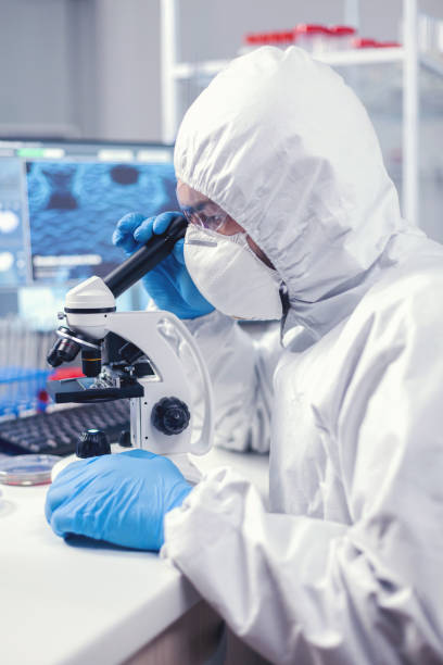 istock Researcher in modern microbiology laboratory uses microscope 1869691091