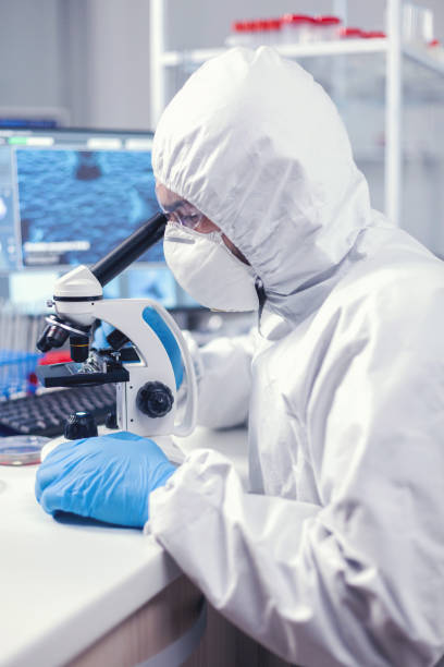 istock Medic in time of global pandemic working on microscope 1869706285