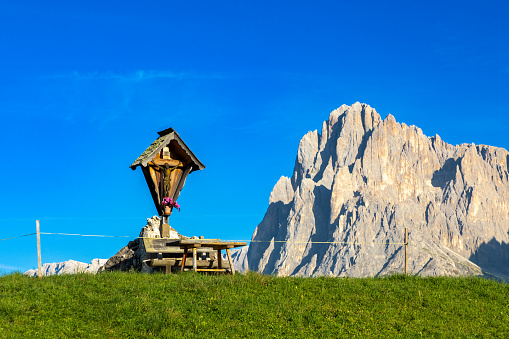 Field cross on Seiser Alm, Alpe di Siusi, in front of Langkofel mountain, South Tyrol