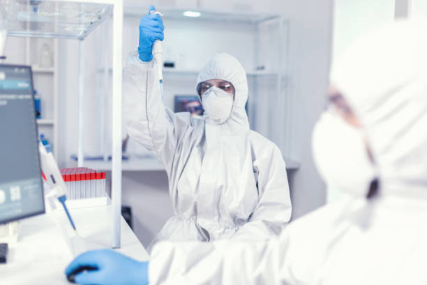 istock Lab scientist in healthcare lab holding micropipette with sample 1869712069