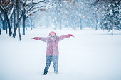 Young Woman Playing With Snow In A Snowy Park In Winter