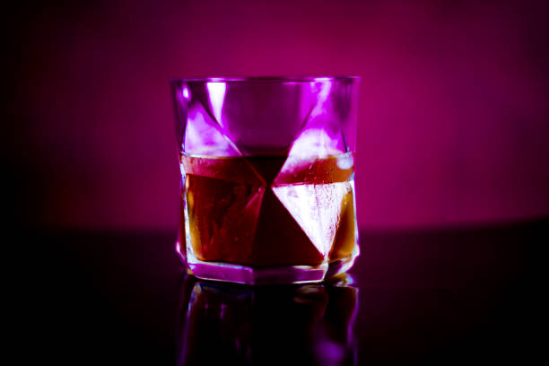 istock Glass od whiskey with a purple background. 1869720041