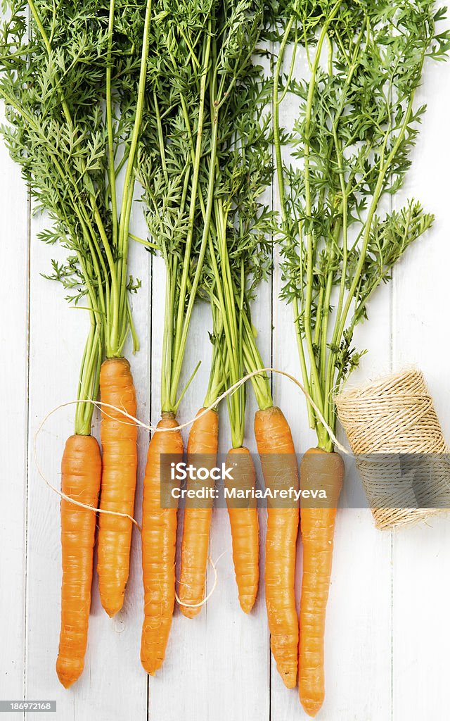 Young rústico zanahorias en pizarras blancas - Foto de stock de Agricultura libre de derechos