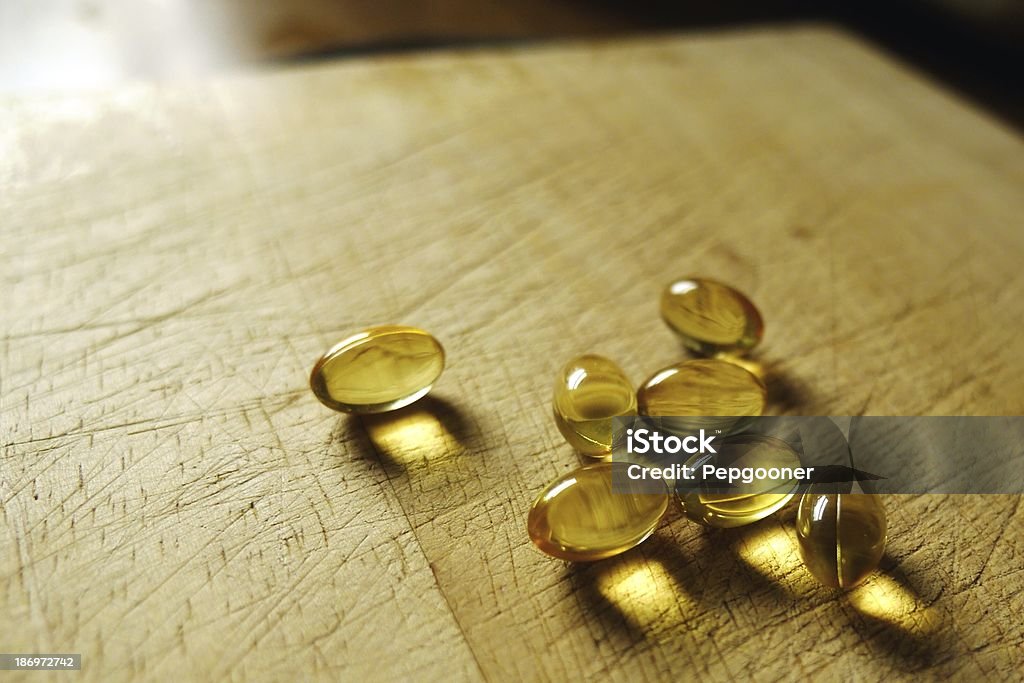 Healthy cod liver oil capsules in a domestic kitchen setting Healthy lifestyle fish oil capsules Bright Stock Photo