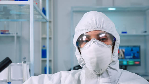 istock Tired doctor wearing coverall looking exhausted at camera 1869728674