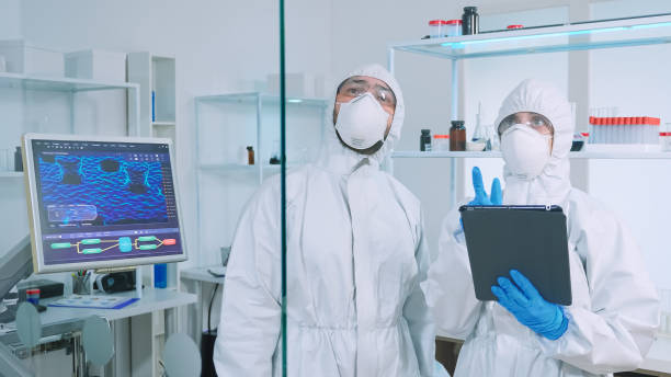 istock Team of scientists in ppe suit using virtual reality in chemistry lab 1869729189