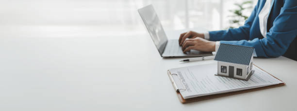 istock House insurance paperwork, A real estate agent is explaining home insurance documents to a buyer in his office at the company, Sign home insurance documents, make an agreement together. 1869733633