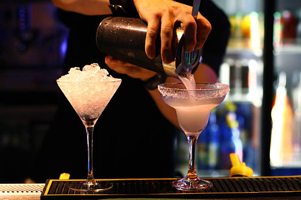 istock A bartender making cocktails in martini glasses 186974296