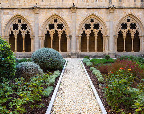 Poblet, Spain - October 8, 2023: Flower garden in the Monastery of Santa Maria de Poblet - famous Abbey and Unesco World Heritage Site, Catalonia