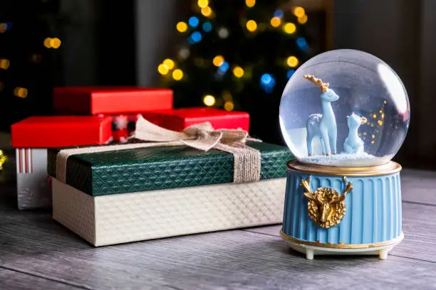 Photo of Christmas Snow Globe with Christmas ornaments and gift boxes
