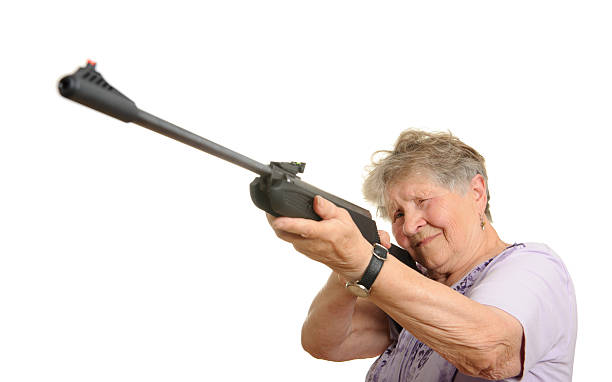 Femme âgée avec un fusil isolé sur blanc - Photo