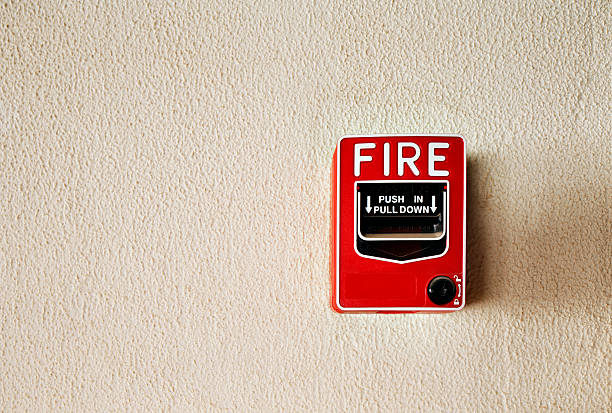Fire alarm button on a wall Every commercial building is required to have a fire alarm emergency break glass box stock pictures, royalty-free photos & images