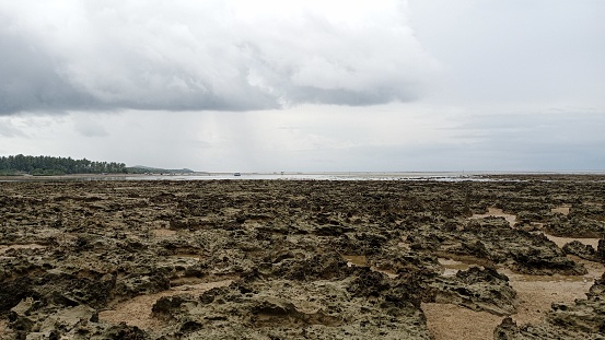 Sea water recedes in the morning on a coastal beach with a slightly cloudy sky b