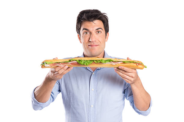 Young Man Eating a Freshly Made Sub Meat Feast San Stock Photo