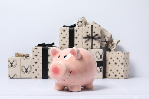 Piggy bank and gift boxes on white background