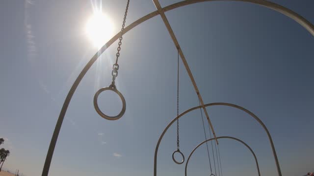 Body Building rings waving on the summer breeze in the famous West Coats location - Venice Beach, near the skate park
