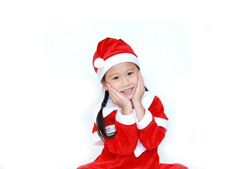 Happy child girl in Santa costume dress with copy space on white background. Merry Christmas and Happy New Year Concept.