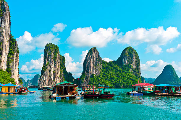 Floating village near rock islands in Halong Bay Floating village and rock islands in Halong Bay, Vietnam, Southeast Asia vietnam stock pictures, royalty-free photos & images